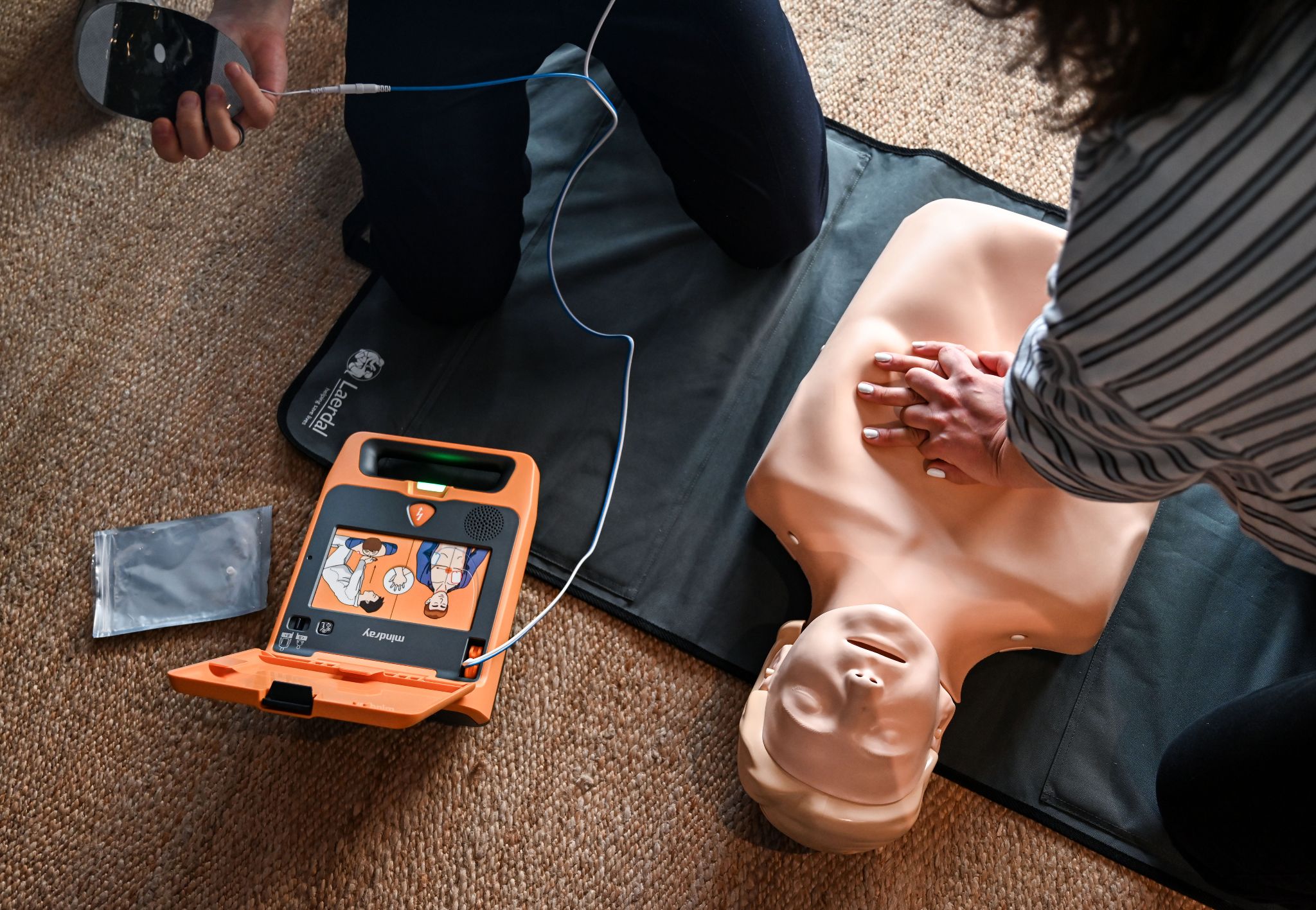 Reanimation mit Mindray BeneHeart C2 AED Defibrillator und angeschlossenen Elektroden bei der Wiederbelebung
